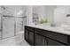 Bathroom featuring double vanity, spacious shower with glass door and white marble-look tiles at 1560 Maidstone Ct, Davenport, FL 33896