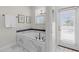 Bathroom featuring soaking tub, white marble-look tile, and a window with blinds at 1560 Maidstone Ct, Davenport, FL 33896