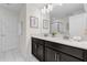 Bright bathroom featuring double sinks, a large mirror, and elegant finishes at 1560 Maidstone Ct, Davenport, FL 33896