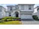 Two-story home featuring an attached two-car garage and well-maintained landscaping at 1560 Maidstone Ct, Davenport, FL 33896