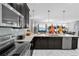 Modern kitchen features stainless steel appliances, sleek countertops, and an open layout to the living area at 1560 Maidstone Ct, Davenport, FL 33896