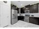 Modern kitchen featuring dark cabinetry, stainless steel appliances, and white marble flooring at 1560 Maidstone Ct, Davenport, FL 33896