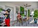 Outdoor dining and entertaining area with a table, green wall, ceiling fans, and access to the backyard at 1560 Maidstone Ct, Davenport, FL 33896