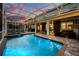 Gorgeous screened-in pool and spa overlooking a spacious patio area with outdoor seating at 1560 Maidstone Ct, Davenport, FL 33896