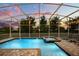 Sparkling pool and spa with a screened-in enclosure and lush landscaping at 1560 Maidstone Ct, Davenport, FL 33896