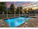 Sparkling screened-in pool and spa area with ample seating and mature trees, ideal for relaxation at 1560 Maidstone Ct, Davenport, FL 33896