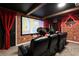 Home theater room with comfortable seating, a large screen, brick accents, and ambient lighting at 1560 Maidstone Ct, Davenport, FL 33896