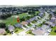 Drone shot showcasing the home in a golf community, with its lawn, landscaping, screened-in pool and other neighborhood homes at 1590 The Oaks Blvd, Kissimmee, FL 34746