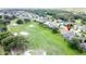 Scenic aerial view of the property highlighting the manicured lawn, mature trees, and proximity to the golf course at 1590 The Oaks Blvd, Kissimmee, FL 34746