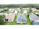Aerial view of neighborhood with golf course and tree coverage at 1590 The Oaks Blvd, Kissimmee, FL 34746
