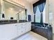 Modern bathroom features double vanity, soaking tub, and walk-in shower with glass enclosure for a luxurious feel at 1590 The Oaks Blvd, Kissimmee, FL 34746