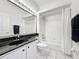 Well-lit bathroom featuring a white tiled shower-tub combo, black granite countertop, and modern fixtures at 1590 The Oaks Blvd, Kissimmee, FL 34746