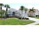 Charming single-story home featuring lush landscaping and palm trees at 1590 The Oaks Blvd, Kissimmee, FL 34746