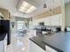 Bright kitchen features tile floors, white cabinets, black countertops, and a cozy breakfast nook at 1590 The Oaks Blvd, Kissimmee, FL 34746