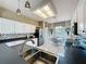 Light-filled kitchen showcases tile floors, white cabinets, black countertops, and modern stainless steel appliances at 1590 The Oaks Blvd, Kissimmee, FL 34746
