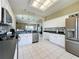 Bright kitchen boasts stainless steel appliances, black countertops, white cabinets, and mosaic backsplash at 1590 The Oaks Blvd, Kissimmee, FL 34746