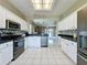 Open concept kitchen featuring white cabinets, black countertops, and stainless steel appliances at 1590 The Oaks Blvd, Kissimmee, FL 34746