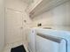 Bright laundry room with washer, dryer, shelves and tiled floor at 1590 The Oaks Blvd, Kissimmee, FL 34746