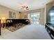 Inviting living room with ceiling fan, plush carpet, sliding glass doors, and comfortable dark sofa at 1590 The Oaks Blvd, Kissimmee, FL 34746