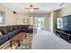 Relaxing living room with large sofa, sliding glass doors, and a ceiling fan at 1590 The Oaks Blvd, Kissimmee, FL 34746