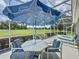 Screened-in patio features a large table and chairs, ideal for enjoying meals with a view of the golf course at 1590 The Oaks Blvd, Kissimmee, FL 34746