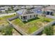 Aerial perspective of a house with solar panels, fenced yard, and lush green lawn at 168 Jensen Dr, Groveland, FL 34736