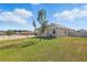 Spacious backyard featuring well-maintained lawn, young tree, and exterior view of the house at 168 Jensen Dr, Groveland, FL 34736