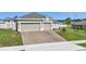 Attractive home featuring a spacious driveway, green lawn, and neatly trimmed landscaping at 168 Jensen Dr, Groveland, FL 34736
