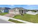 Well-maintained home with a paved driveway, manicured lawn, and attractive landscaping at 168 Jensen Dr, Groveland, FL 34736
