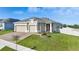 Well-maintained home featuring a three car garage, brick driveway, and verdant, landscaped front yard at 168 Jensen Dr, Groveland, FL 34736