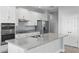 Bright kitchen featuring an island with gray countertops, white cabinets, and stainless steel appliances at 168 Jensen Dr, Groveland, FL 34736