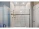 Modern shower featuring marble-style tile, glass door, and designer fixtures at 168 Jensen Dr, Groveland, FL 34736