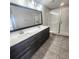 Modern bathroom featuring a double vanity with stone counter and a glass-enclosed shower with tiled walls at 191 Aidans Lndg, Haines City, FL 33844