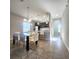 Bright dining room featuring modern lighting, a glass-top table, and seating for six near an open kitchen at 191 Aidans Lndg, Haines City, FL 33844