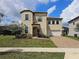 Charming two-story home with a well-manicured lawn and a brick driveway and white window shutters at 191 Aidans Lndg, Haines City, FL 33844