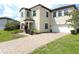 Charming two-story home with a well-manicured lawn and a brick driveway and white window shutters at 191 Aidans Lndg, Haines City, FL 33844