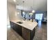 Modern kitchen island featuring a stainless dishwasher, sink, and seating at 191 Aidans Lndg, Haines City, FL 33844