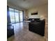 Bright living room with tiled floors, modern furniture, and sliding glass doors to the outdoor pool area at 191 Aidans Lndg, Haines City, FL 33844