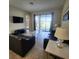 Open-concept living space with tiled floors, modern furniture, and sliding glass doors to the outdoor pool at 191 Aidans Lndg, Haines City, FL 33844