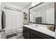 Cozy bathroom featuring dark wood vanity with white countertop, shower with curtain, and decorative plants at 2151 Valencia Blossom St, Clermont, FL 34711