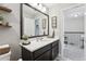 Bathroom with dark cabinets, white countertop, and decorative wall art, leading to the upstairs hallway at 2151 Valencia Blossom St, Clermont, FL 34711