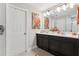 Elegant bathroom with a double vanity, stylish lighting, and a large mirror at 2151 Valencia Blossom St, Clermont, FL 34711