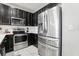 Close-up of the stainless steel refrigerator and oven with black modern cabinets at 2151 Valencia Blossom St, Clermont, FL 34711