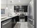 Modern kitchen featuring stainless steel appliances, dark cabinetry, and stylish white countertops at 2151 Valencia Blossom St, Clermont, FL 34711