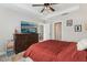 Well-lit main bedroom with a large dresser, ceiling fan, and access to the bathroom and living areas at 2151 Valencia Blossom St, Clermont, FL 34711