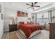 Comfortable bedroom featuring a tufted headboard, soft lighting, and a ceiling fan at 2151 Valencia Blossom St, Clermont, FL 34711