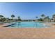 Community pool with various seating options, sun deck, and surrounding palm trees at 2151 Valencia Blossom St, Clermont, FL 34711