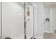Modern walk-in shower with white subway tile, glass door, and wooden shelving for toiletries at 2151 Valencia Blossom St, Clermont, FL 34711