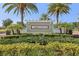 Community sign amidst lush landscaping featuring tall palm trees and manicured shrubbery at 2151 Valencia Blossom St, Clermont, FL 34711