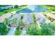 Aerial view of landscaped homes in community surrounding lake with fountain at 233 Rialto Rd, Kissimmee, FL 34759